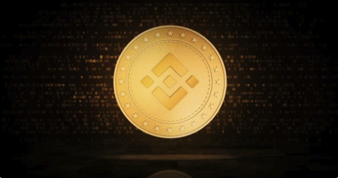 A gold Binance coin with a black background